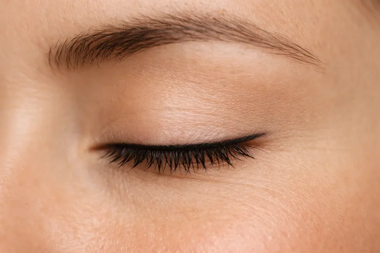 Gros plan sur un œil fermé avec ras de cil permanent discret sur les cils supérieurs